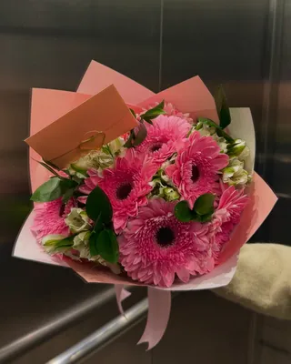 Ramo de gerberas fucsia y follaje, entregado en un ascensor