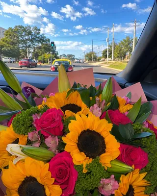 Ramo de girasoles y flores de colores dentro del auto de reparto