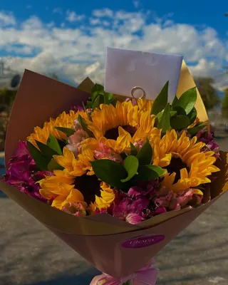 Ramo de girasoles con flores moradas entregado en la calle